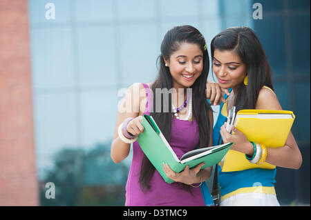 University students reading a book in university campus Stock Photo