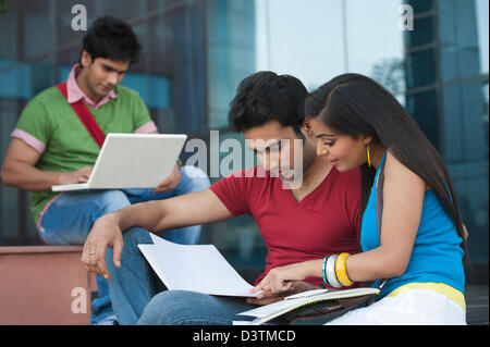 University students discussing on notes in university campus Stock Photo