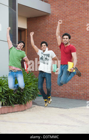 University students jumping together in university campus Stock Photo