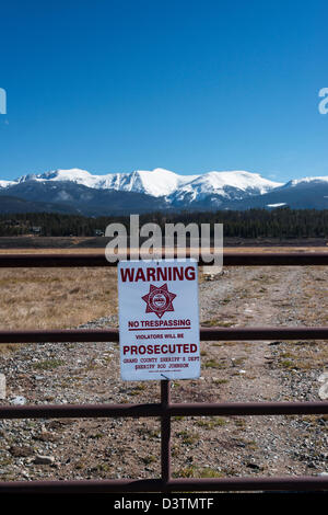 No trespassing sign on a gate closing the road to private property Stock Photo