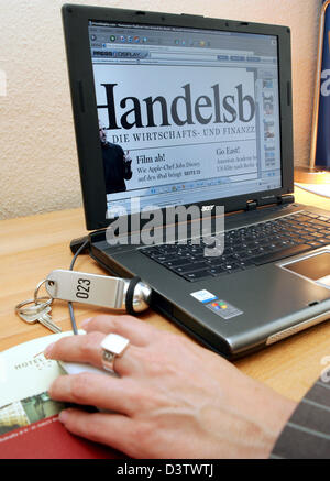 A young woman reads the newspaper 'Handelsblatt' in the Internet in the business Hotel Gates in Berlin, Germany, Wednesday, 13 June 2006. Guests of the hotel have access to the free newspaper offering of 'Pressdisplay' in every room. 250 newspapers from 55 countries in 35 languages can be read online, sometimes even before print. Photo: Gero Breloer Stock Photo