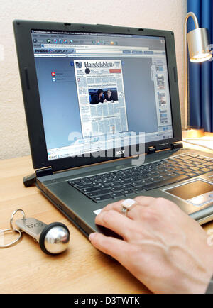 A young woman reads the newspaper 'Handelsblatt' in the Internet in the business Hotel Gates in Berlin, Germany, Wednesday, 13 June 2006. Guests of the hotel have access to the free newspaper offering of 'Pressdisplay' in every room. 250 newspapers from 55 countries in 35 languages can be read online, sometimes even before print. Photo: Gero Breloer Stock Photo