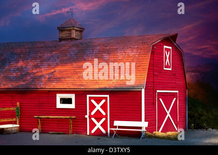 Old Red Barn with Bench and Well Stock Photo