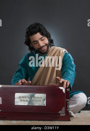 Musician playing a harmonium Stock Photo