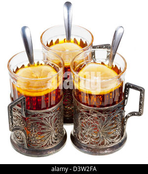 retro glasses in old cupronickel glass holders with black tea and lemon isolated on white background Stock Photo