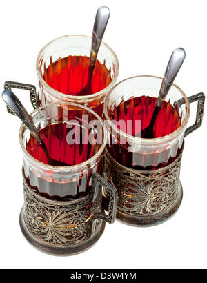 three retro glasses in silver glass holders with spoon with black tea isolated on white background Stock Photo
