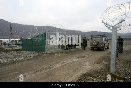 A KFOR vehicle passes the heavely guarded gate of the fortified Bundeswehr camp 'Nothing Hill'  north of Mitrovica, Serbia, 11 December 2006. Administrated by the UN the Kosovo forms part of Serbia under international law. The camp erected only in July 2006 is the northernmost post of the KFOR troops in the Kosovo. Photo: Matthias Schrader Stock Photo