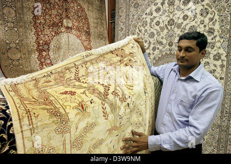 Mosharraf, the owner of  'Persian Carpet House', shows a carpet from his wide variety in his carpet shop at the Madinat Jumeirah Shopping-Center in Dubai, United Arab Emirates (UAE), 07 January 2007. Photo: Daniel Karmann Stock Photo