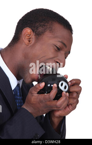 Man trying to break into a piggy bank with a hammer Stock Photo - Alamy