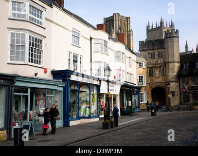 Shops in Market Place with Penniless Porch and the cathedral, Wells, Somerset, England Stock Photo