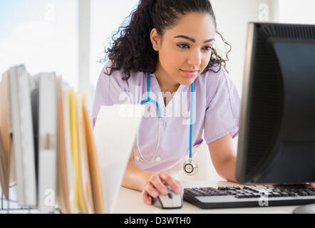 Hispanic nurse using computer in hospital Stock Photo