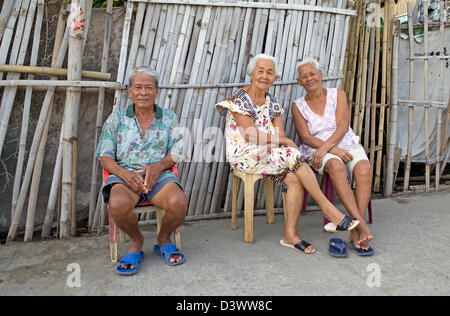 Three Senior Filipino adults sit together. Stock Photo