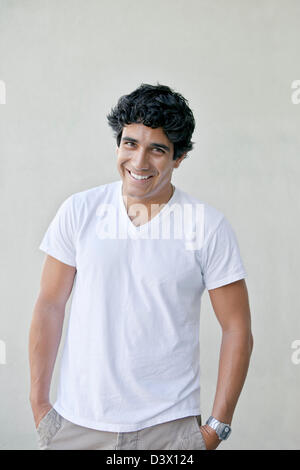 Smiling portrait of young adult mexican-american male wearing plain white t-shirt and khakis Stock Photo