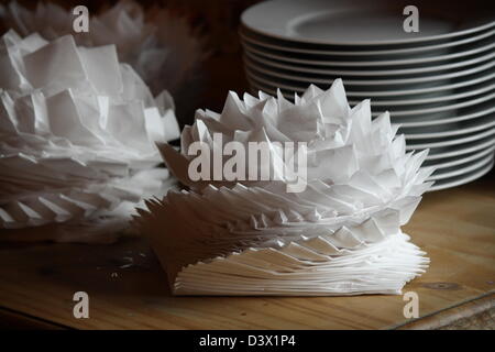 Plates and serviettes piled up in the style of origami. Stock Photo