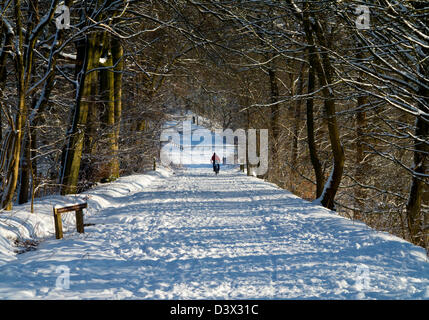 High Peak Trail in heavy winter snow near Wirksworth Derbyshire Dales Peak District England UK with cyclist in distance