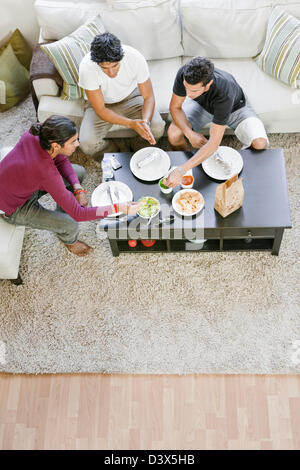 Hispanic-American Men Eating Burrito, Mexican Food in Living Room Stock Photo