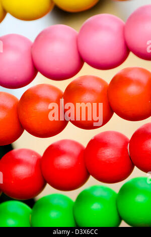 Detail of colourful wooden balls on an abacus used to teach young children how to count Stock Photo