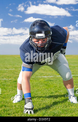 Caucasian football player poised on field Stock Photo