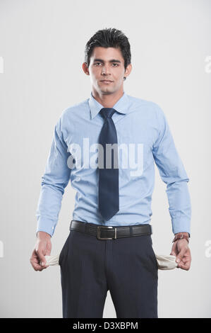 Businessman showing his empty pockets Stock Photo