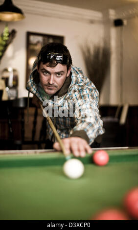 Pool player at billiards table, St Agnes, Cornwall, UK Stock Photo