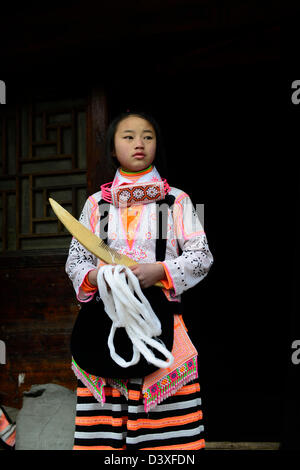 A Long Horn Miao teenage girl getting ready for the Tiao Hua festival in Guizhou. Stock Photo