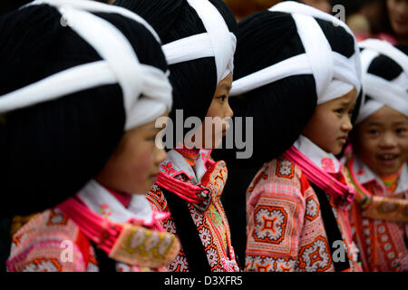 A Long Horn Miao little girl in traditional costumes dancing to celebrate the Tiao Hua festival / spring in Guizhou. Stock Photo