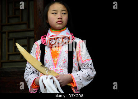 A Long Horn Miao teenage girl getting ready for the Tiao Hua festival in Guizhou. Stock Photo