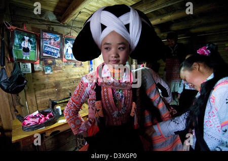 A Long Horn Miao teenage girl getting ready for the Tiao Hua festival in Guizhou. Stock Photo