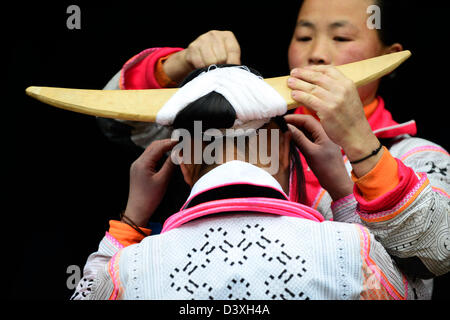 A Long Horn Miao teenage girl getting ready for the Tiao Hua festival in Guizhou. Stock Photo