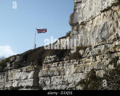 Rock face of Portland stone - union Jack flag flying above Stock Photo