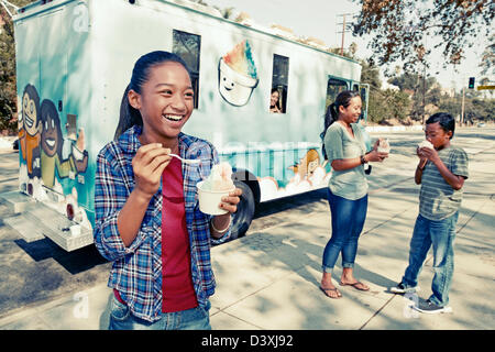Girl eating ice cream from truck Stock Photo