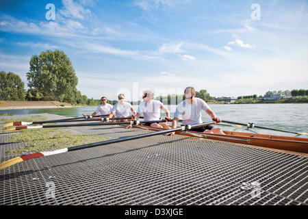 Teamwork Concept of Men Rowing Team Mounting Boat in Coordination Stock Photo