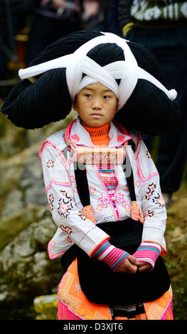 A Long Horn Miao little girl in traditional costumes dancing to celebrate the Tiao Hua festival / spring in Guizhou. Stock Photo