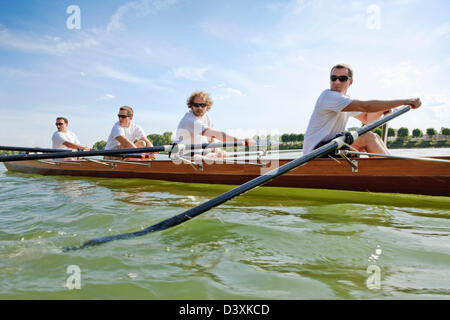 Teamwork and Coordination Concept of Friends in Men Rowing Team Stock Photo