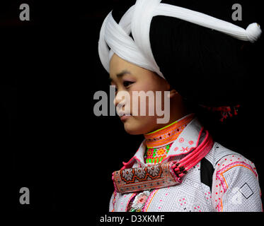 A Long Horn Miao teenage girl getting ready for the Tiao Hua festival in Guizhou. Stock Photo