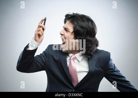 Frustrated businessman shouting over a mobile phone Stock Photo