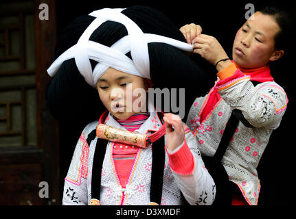 A Long Horn Miao teenage girl getting ready for the Tiao Hua festival in Guizhou. Stock Photo