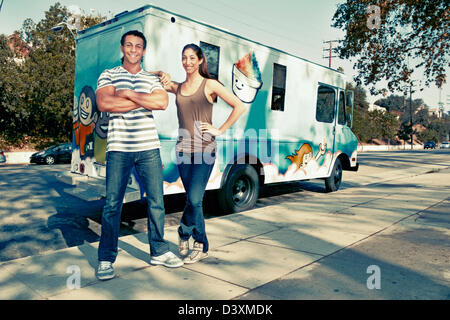 Couple standing by ice cream truck Stock Photo