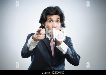 Businessman shouting through a paper megaphone Stock Photo