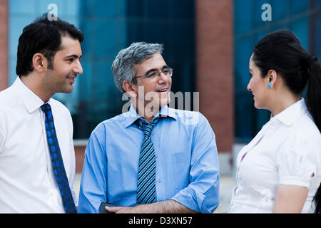 Business executives discussing outside an office building Stock Photo