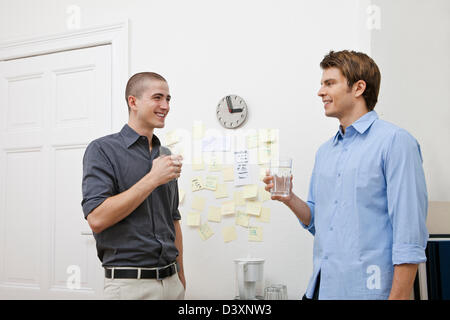 Office workers chatting in the pantry while taking a break Stock Photo