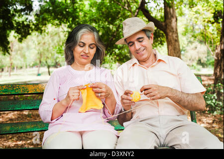 Mature couple knitting together in a park, Lodi Gardens, New Delhi, India Stock Photo