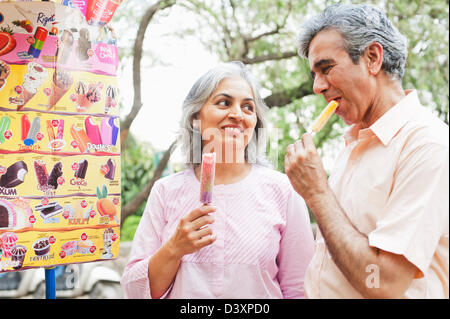 Mature couple eating ice cream candies, Lodi Gardens, New Delhi, India Stock Photo