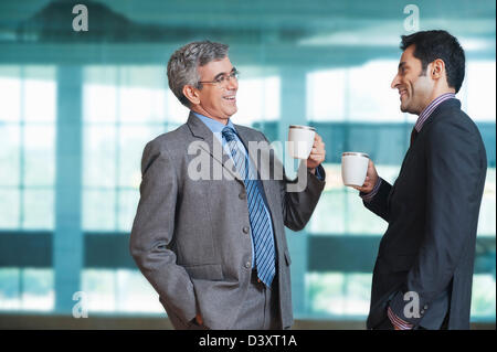 Two businessmen having coffee and smiling Stock Photo
