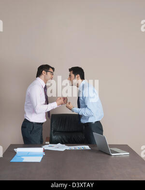 Two businessmen fighting to each other Stock Photo