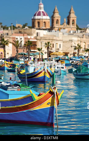 Traditional Maltese fishing boat.Parish Church,Marsaxlokk,Malta. Stock Photo