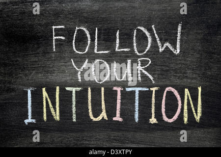 follow your intuition phrase handwritten on blackboard Stock Photo