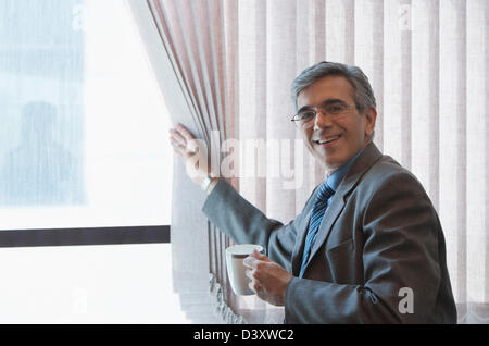 Businessman drinking coffee and smiling Stock Photo