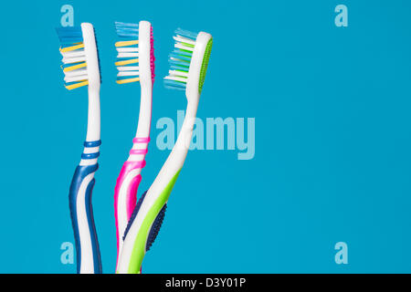 Three tooth brushes on the blue background Stock Photo