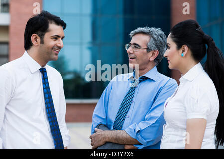Business executives discussing outside an office building Stock Photo